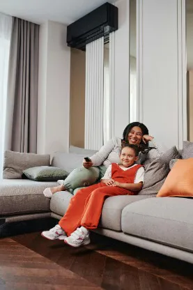 Mother and daughter relaxing in air conditioned living room